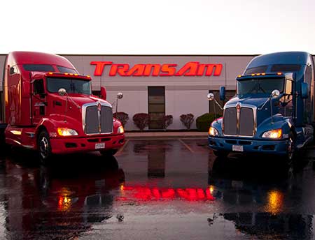 Red and blue truck outside the TransAm Trucking building